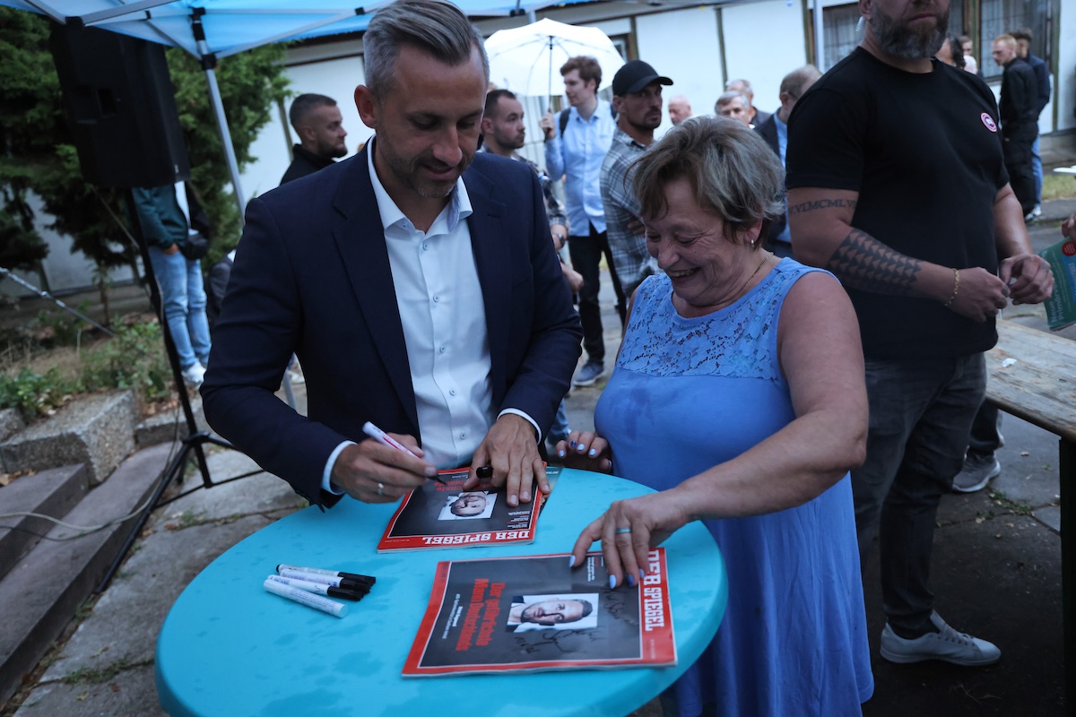 Il candidato di AfD in Sassonia-Anhalt, Ulrich Siegmund, autografa copie della rivista Der Spiegel che gli ha dedicato la copertina definendolo «l'uomo più pericoloso della Germania», il 19 agosto a Dessau-Rosslau