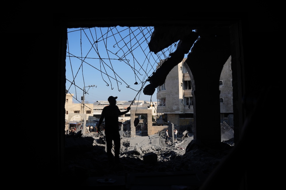 Palestinesi tra le macerie della moschea di Abu Salim, il giorno dopo un attacco aereo israeliano (AP Photo/Abdel Kareem Hana)