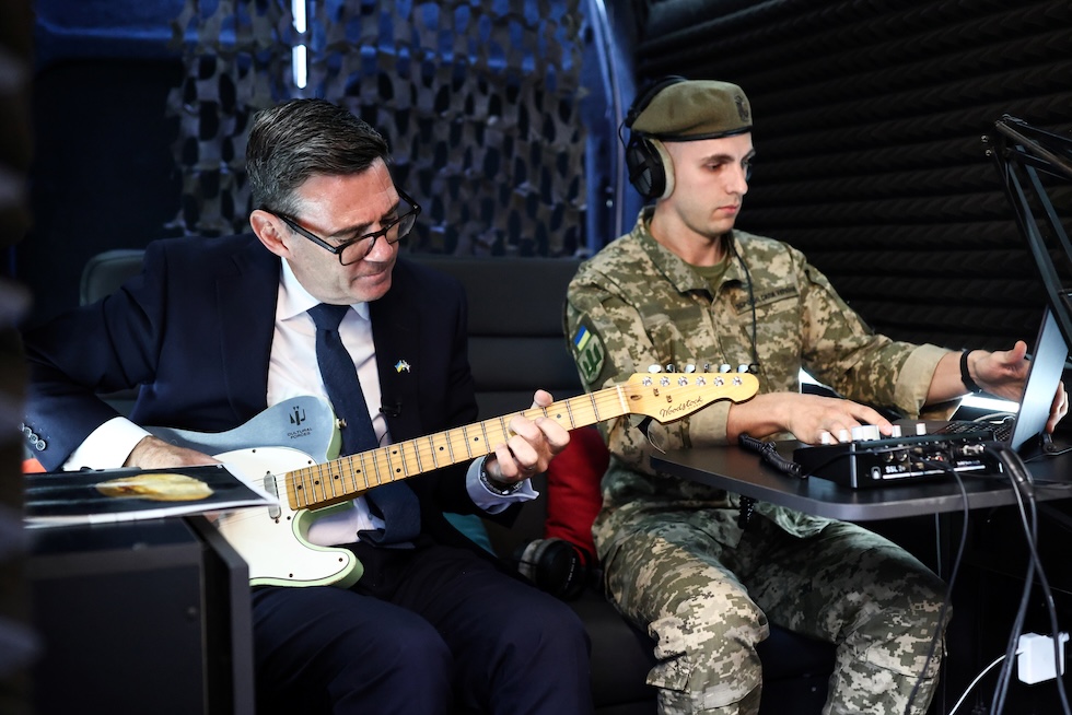 Il primo ministro britannico Andy Burnham suona la chitarra nello studio di registrazione mobile dell’unità militare e artistica "Cultural Forces Frontline", i cui membri si esibiscono al fronte, negli ospedali e nei centri di riabilitazione. La foto è stata scattata ieri (Henry Nicholls/Pool Photo via AP)