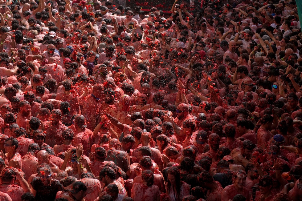 I partecipanti alla Tomatina, la festa che si tiene ogni ultimo mercoledì di agosto, si tirano pomodori addosso come da tradizione (AP Photo/Alberto Saiz)