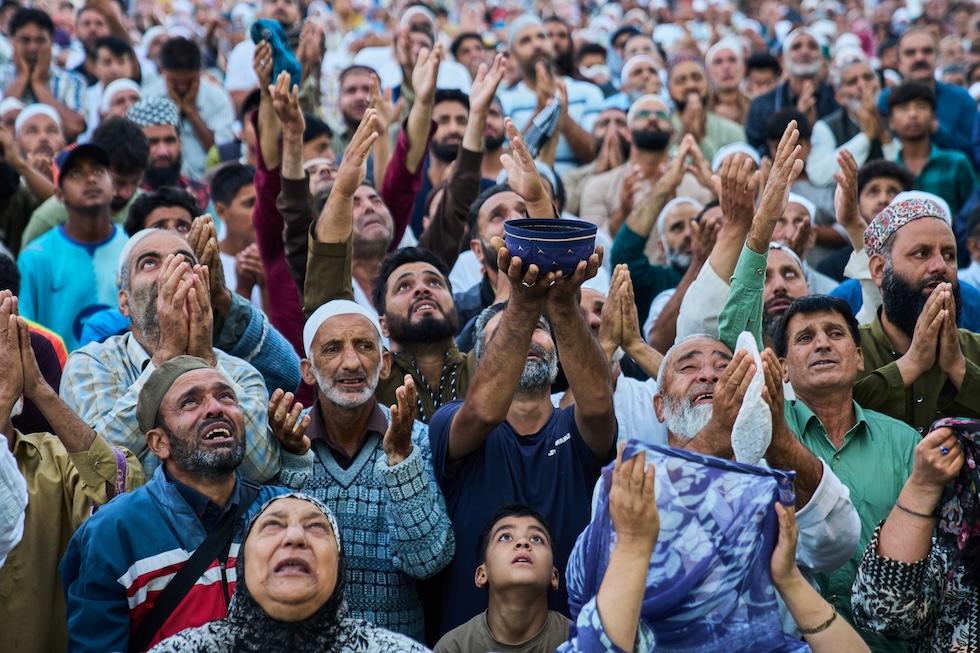 Fedeli musulmani alzano le mani verso una reliquia, ritenuta un pelo della barba del profeta Maometto, esposta da un sacerdote nel santuario di Hazratbal durante l’Eid-e-Milad, la festa che commemora la nascita del profeta (AP Photo/Dar Yasin)