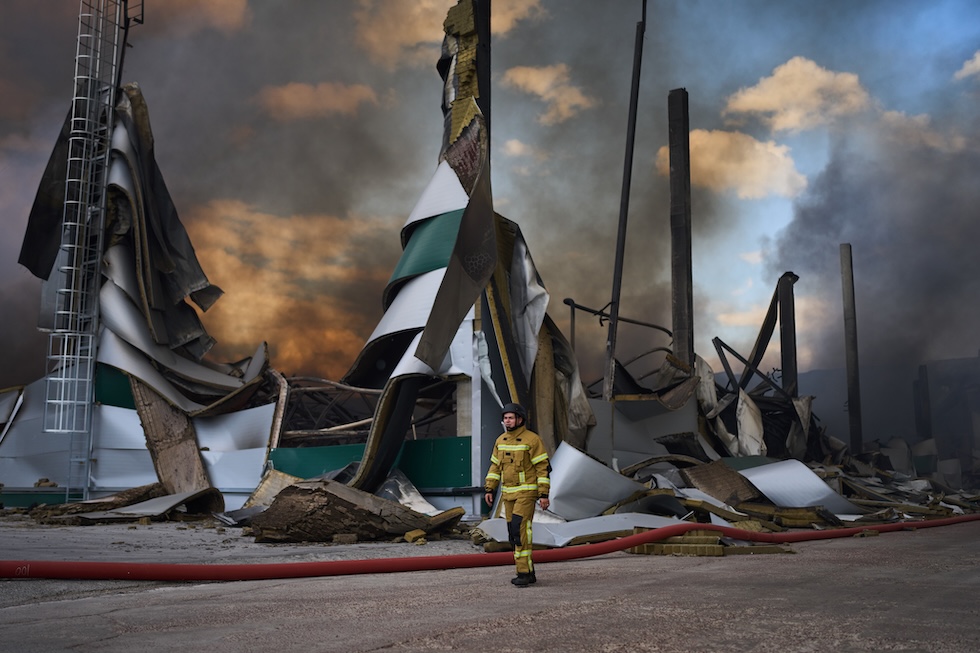 Un vigile del fuoco vicino a un magazzino colpito dagli attacchi dei droni russi (AP Photo/Francisco Seco)