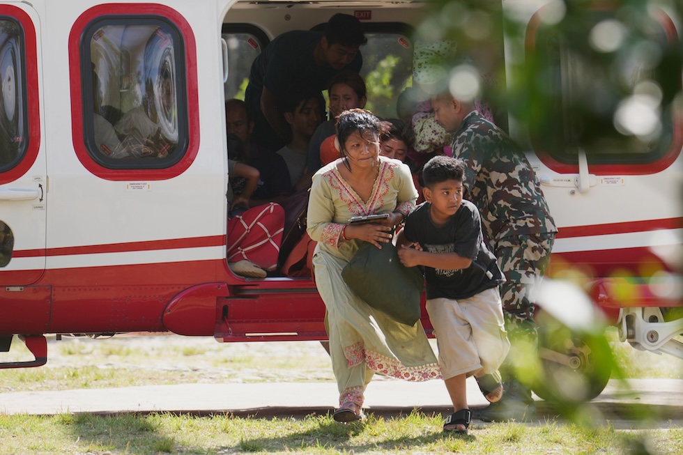 Persone scendono da un elicottero dopo essere state soccorse per l'esondazione che ha provocato la morte di almeno 475 persone (AP Photo/Rajesh Kumar Singh)