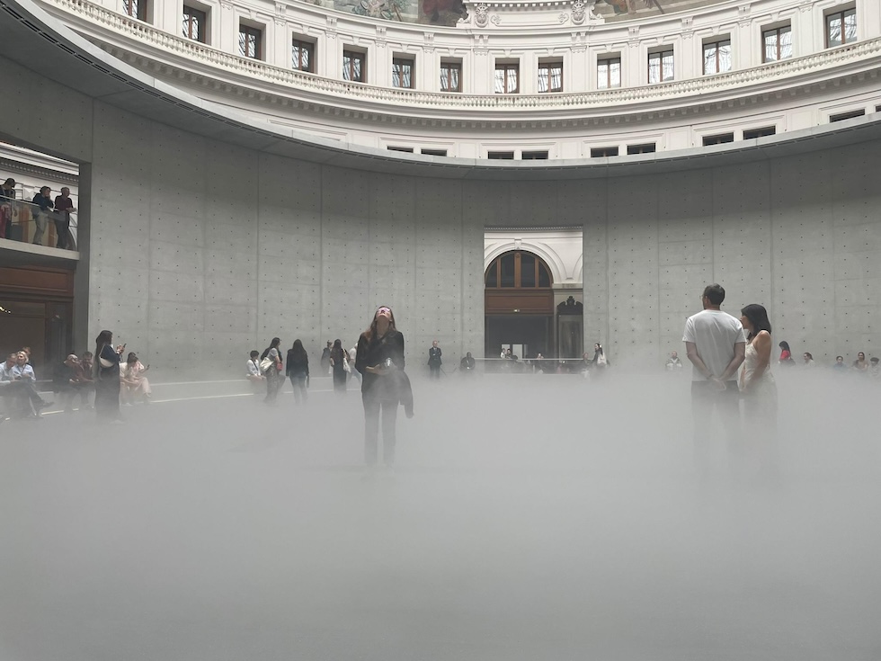 Visitatori nell'installazione Cloud #07156, una scultura di nebbia opera dell'artista giapponese Fujiko Nakaya alla Bourse de Commerce (ANSA)