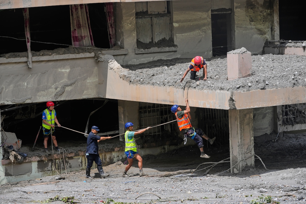 Le ricerche dei sopravvisuti in un edificio vicino al fiume esondato, nel distretto di Nuwakot, il 29 agosto