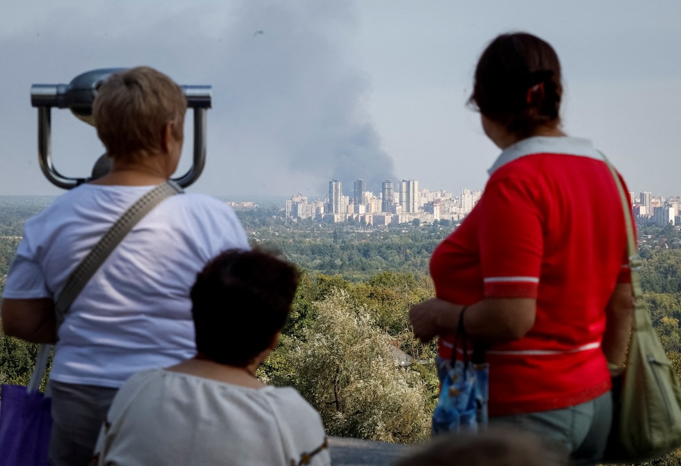 Persone guardano il fumo causato da un attacco di droni russo (REUTERS/Gleb Garanich)