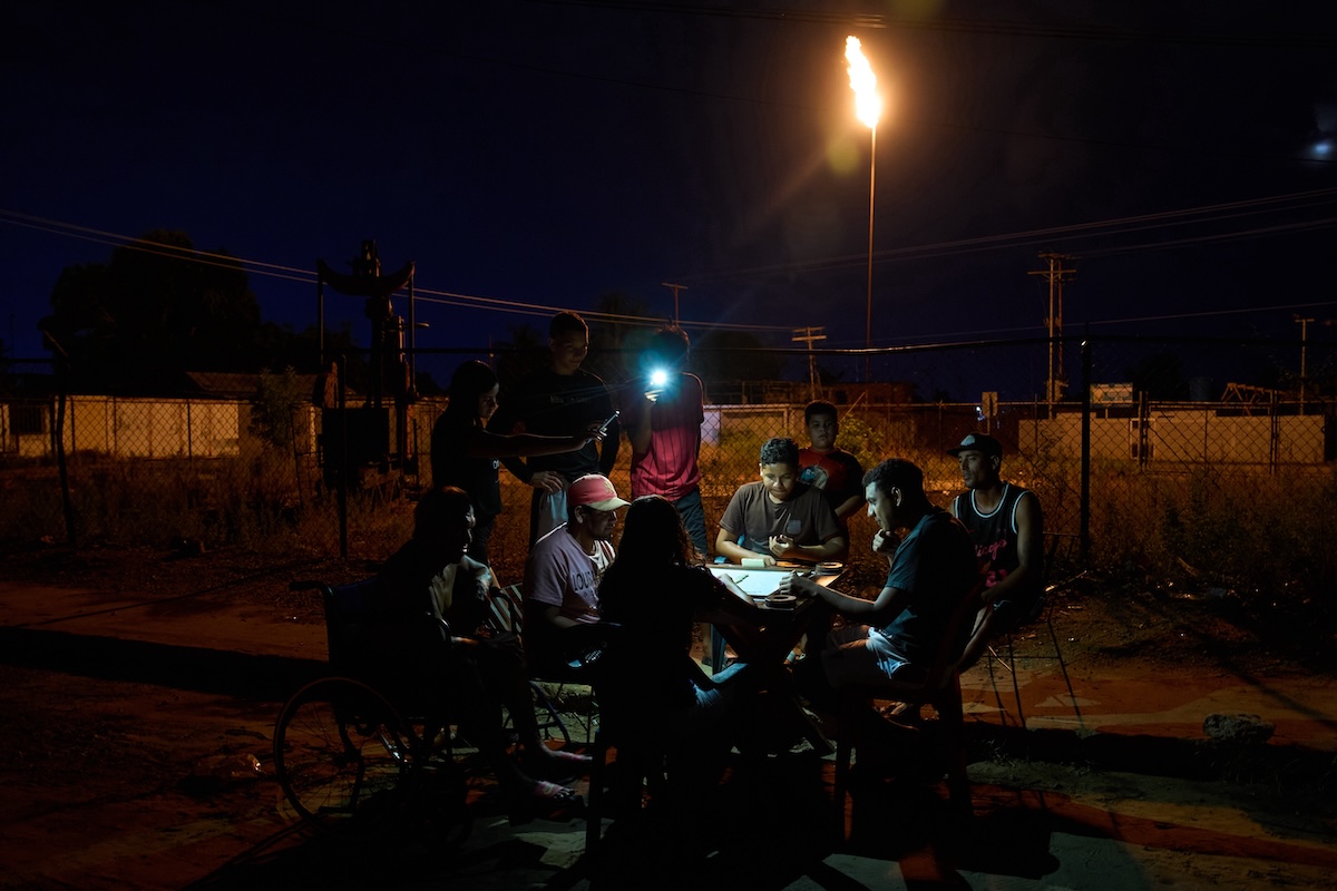 Persone giocano a carte durante un blackout in Venezuela, a Cabimas, il 31 agosto