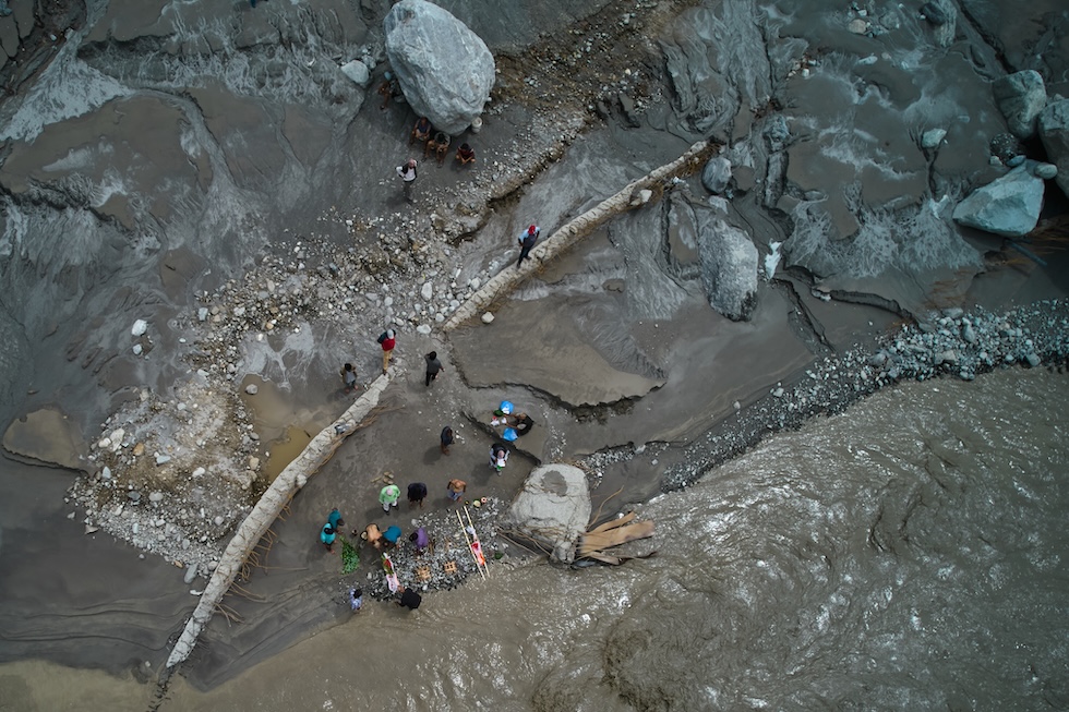 Alcune persone eseguono riti funebri simbolici per i loro familiari dispersi e ormai considerati morti, sulle rive del fiume Trishuli  (AP Photo/Rajesh Kumar Singh)
