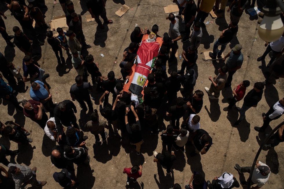 Il funerale di un diciannovenne ucciso dalle forze armante israeliane durante gli scontri tra palestinesi e coloni israeliani  (AP Photo/Leo Correa)

