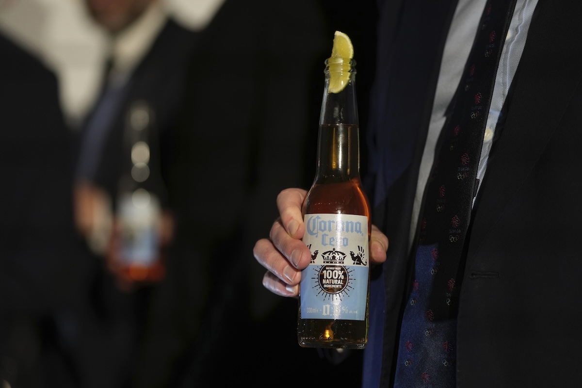 Una persona con in mano una bottiglia di birra analcolica