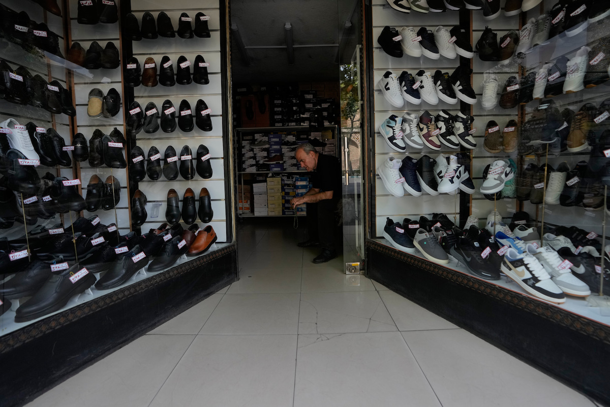 Un commerciante di scarpe a Teheran, agosto 2026 (AP Photo/Vahid Salemi)
