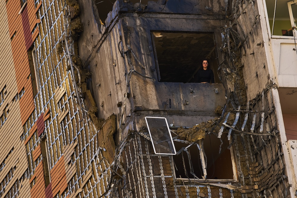 Una donna guarda fuori da ciò che resta della finestra di un edificio residenziale colpito da un attacco russo  (AP Photo/Francisco Seco)
