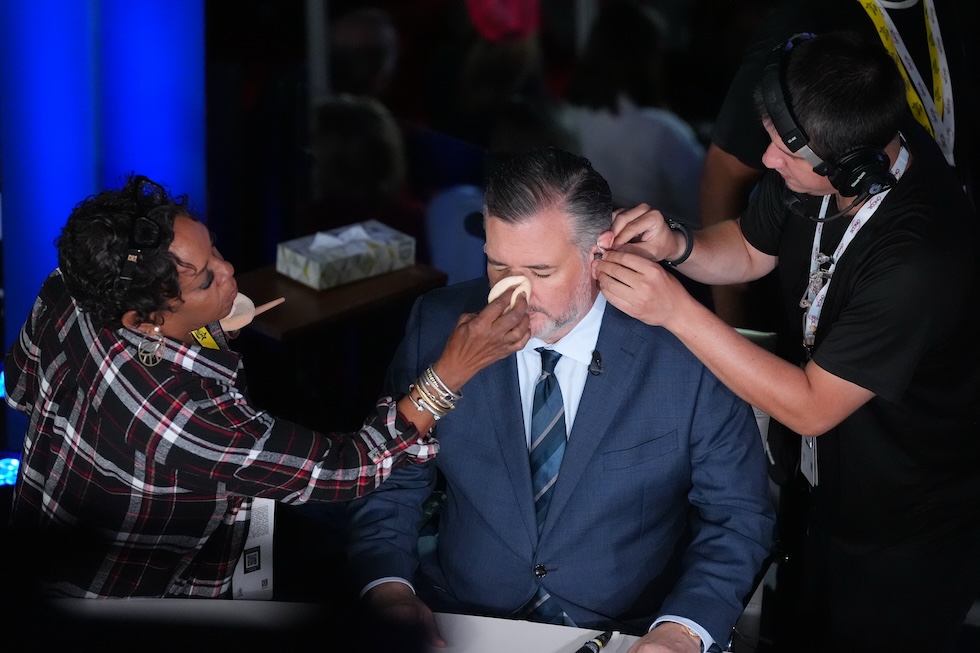 Il senatore statunitense Ted Cruz mentre gli mettono trucco e microfono per un'apparizione televisiva alla convention del partito Repubblicano (AP Photo/Tony Gutierrez)
