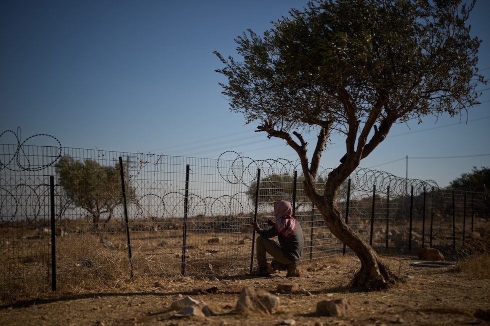 Un uomo lavora alla recinzione della casa della sua famiglia palestinese-beduina per cercare di prevenire gli attacchi dei coloni israeliani (AP Photo/Leo Correa)