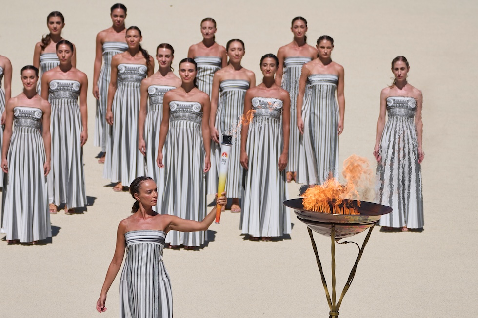 L’attrice Katerina Misichroni accende una fiaccola dal braciere durante la cerimonia di consegna della fiamma dei Giochi olimpici giovanili di Dakar (AP Photo/Petros Giannakouris)