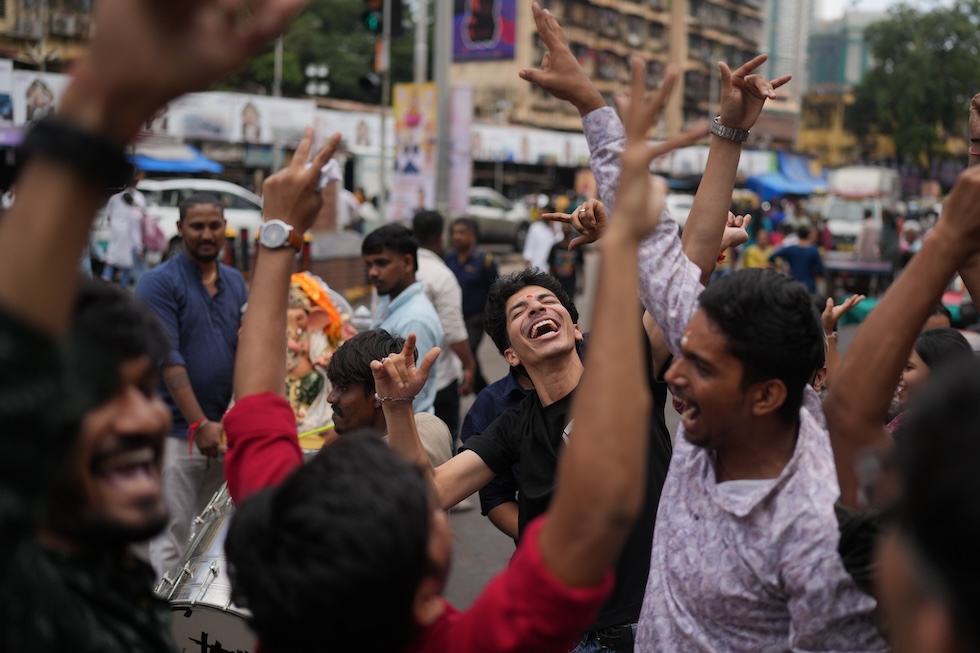 Persone danzano in occasione di una festa induista dedicata alla nascita del dio Ganesha (AP Photo/Rafiq Maqbool)