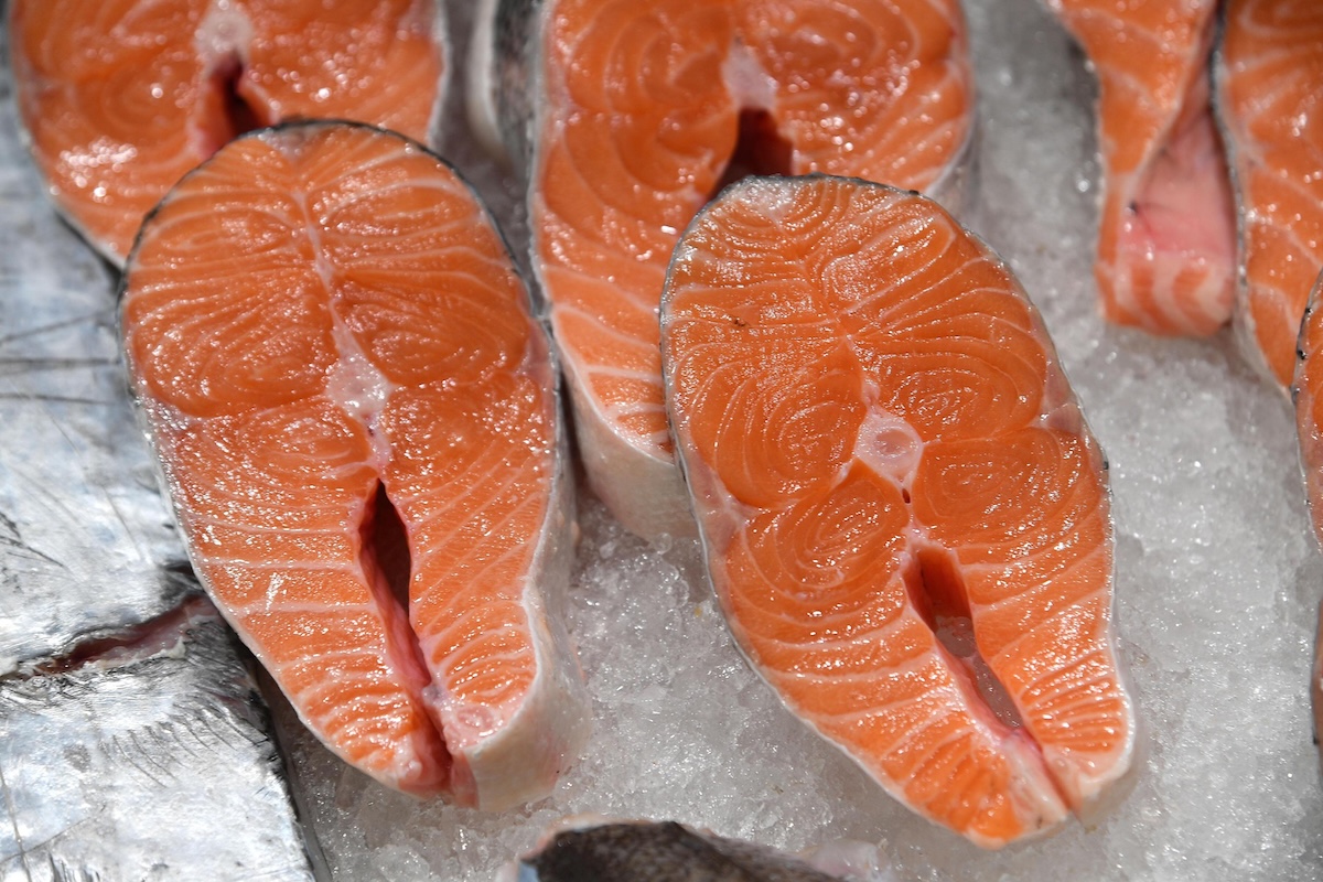 Tranci di salmone esposti su un banco