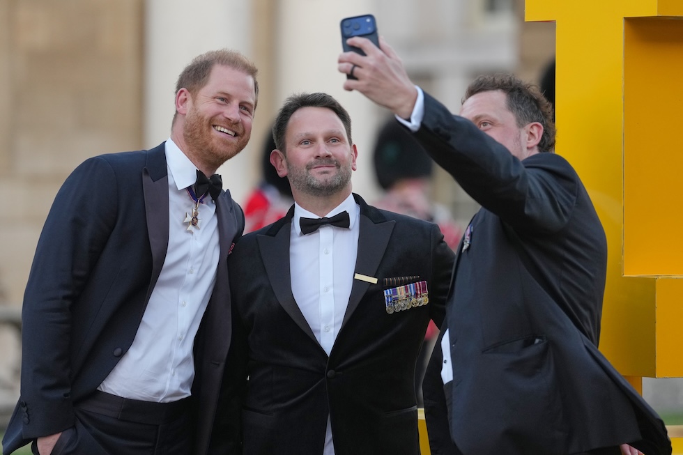 Il principe Harry posa per una fotografia con alcuni ex soldati al suo arrivo agli Invictus Spirit Awards (AP Photo/Alastair Grant)