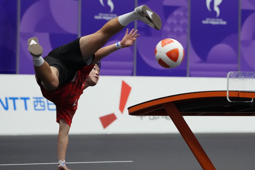 Il sudcoreano Kim Eunjun calcia il pallone contro un avversario del Kirghizistan durante la gara di doppio misto di teqball ai Giochi asiatici (AP Photo/Aaron Favila)