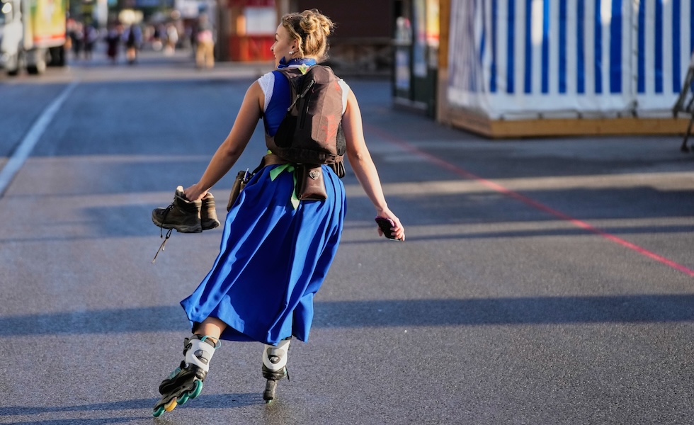 Una cameriera dell'Oktoberfest va al lavoro sui pattini (Matthias Schrader/AP)