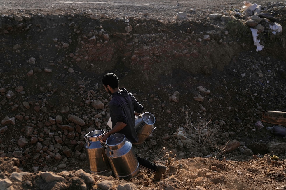 Un allevatore palestinese va nel villaggio di Khirbet al Malih per vendere del latte (Majdi Mohammed/AP)