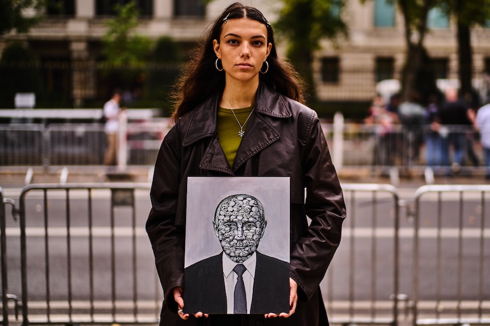 Una donna tiene in mano un ritratto del presidente russo Vladimir Putin nel giorno delle elezioni per il rinnovo del parlamento (Markus Schreiber/AP)