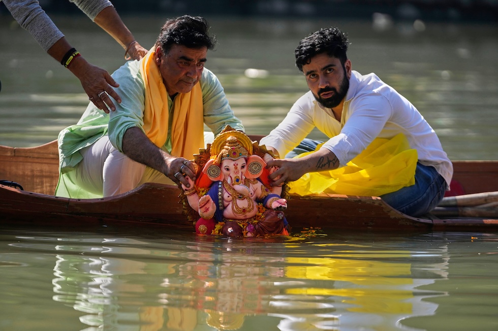 I fedeli pandit del Kashmir immergono una statua di Ganesha, la divinità indù dalla testa di elefante, nel fiume Jhelum a Srinagar, (Mukhtar Khan/AP)