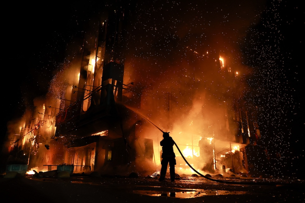 Un soccorritore spegne un incendio al centro commerciale Intrade in seguito a un attacco di droni russi (AP Photo/Evgeniy Maloletka)
