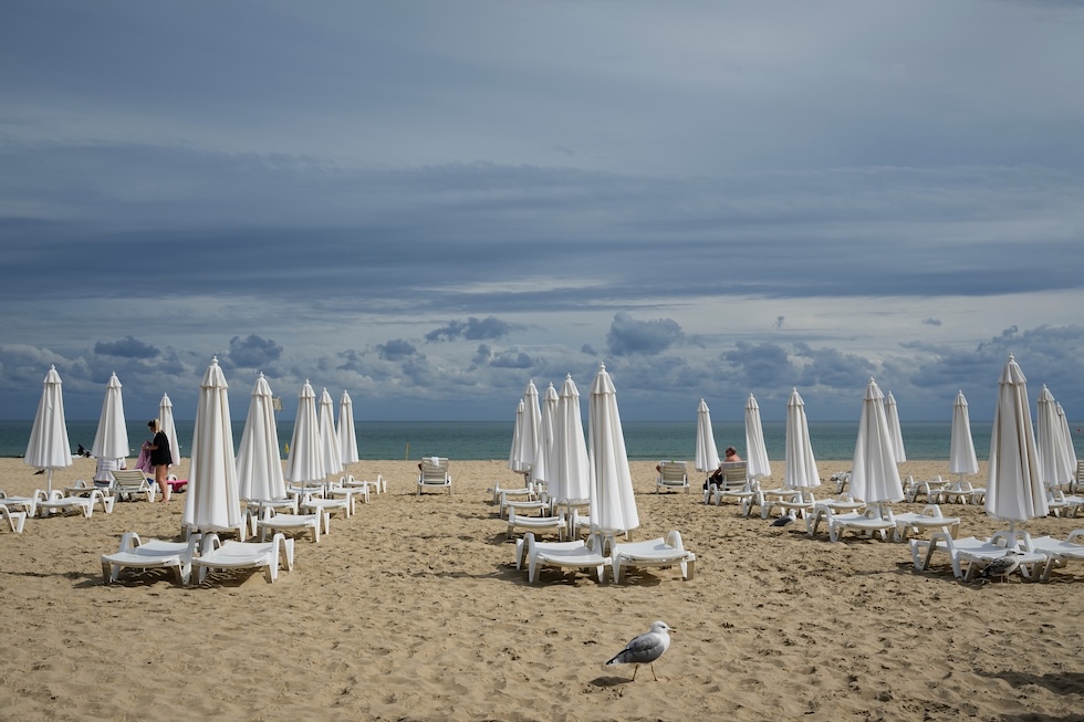 Alcune persone in uno stabilimento balneare in una giornata autunnale (AP Photo/Sergei Grits)