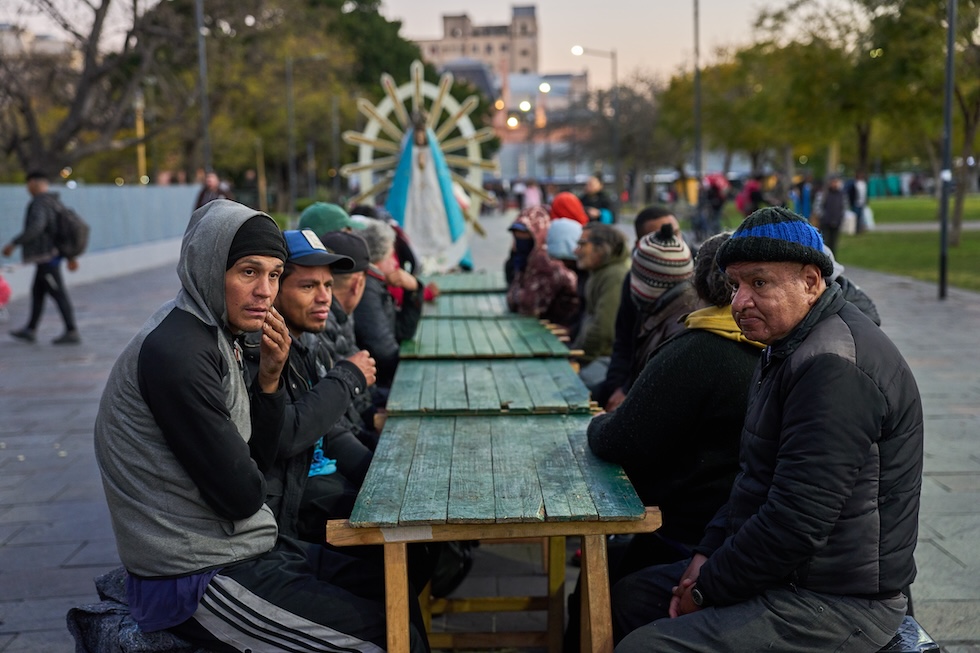 Alcuni uomini in attesa di ricevere un pasto gratuito in una piazza davanti alla stazione ferroviaria Constitución (AP Photo/Rodrigo Abd)