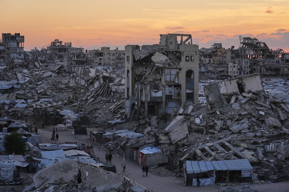 Palestinesi tra gli edifici distrutti dai bombardamenti, ieri 23 settembre (AP Photo/Jehad Alshrafi)