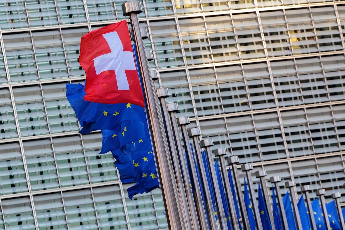 Una bandiera svizzera fuori dal palazzo della Commissione Europea a Bruxelles durante un incontro negoziale di marzo 2026