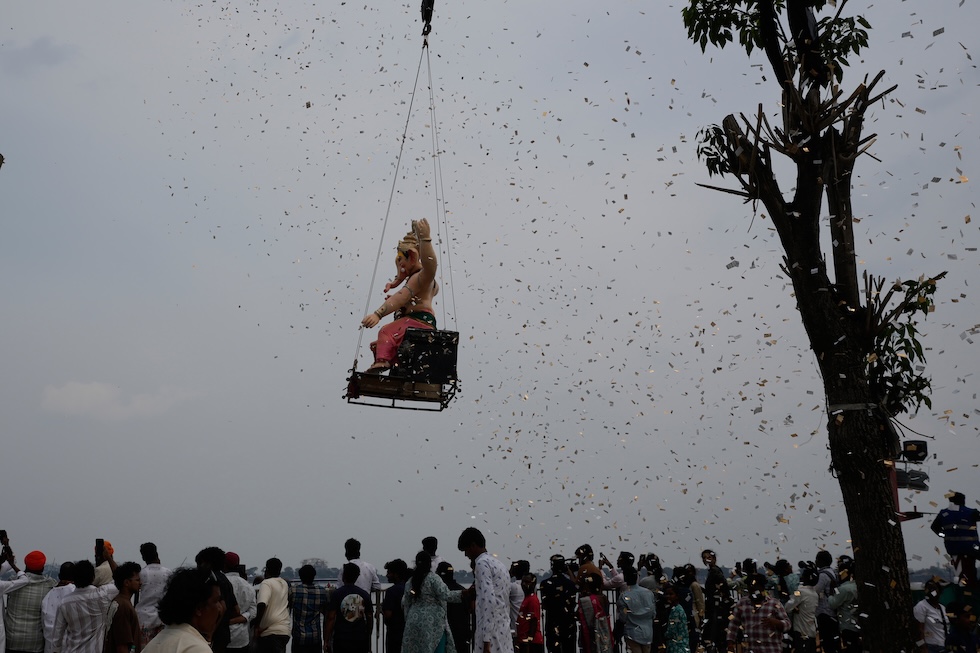 Una statua del dio indù Ganesha, viene sollevata con delle gru per essere immersa nel lago Hussain Sagar, nell’ultimo giorno del festival Ganesh Chaturthi (AP Photo/Mahesh Kumar A.)