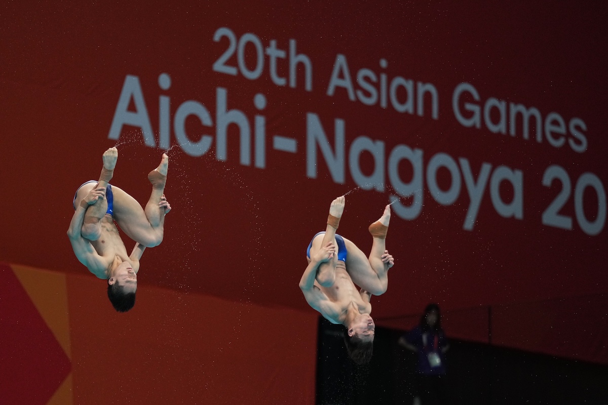 Gli atleti cinesi Wang Zongyuan e Zheng Jiuyuan gareggiano nella finale del trampolino sincronizzato da 3 metri ai Giochi Asiatici di Tokyo (AP/Hiro Komae)