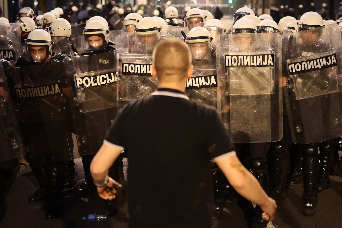 Un manifestante davanti alla polizia durante una protesta contro il governo a Belgrado, il 23 maggio 2026 (AP/Armin Durgut)