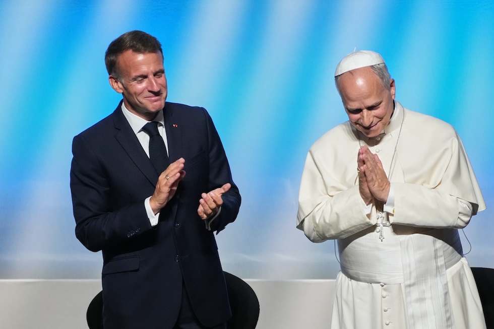 Il presidente francese Emmanuel Macron applaude papa Leone XIV dopo il suo discorso a un incontro intitolato "Alle radici dell'Europa per la pace e l'unità" (AP Photo/Gregorio Borgia)
