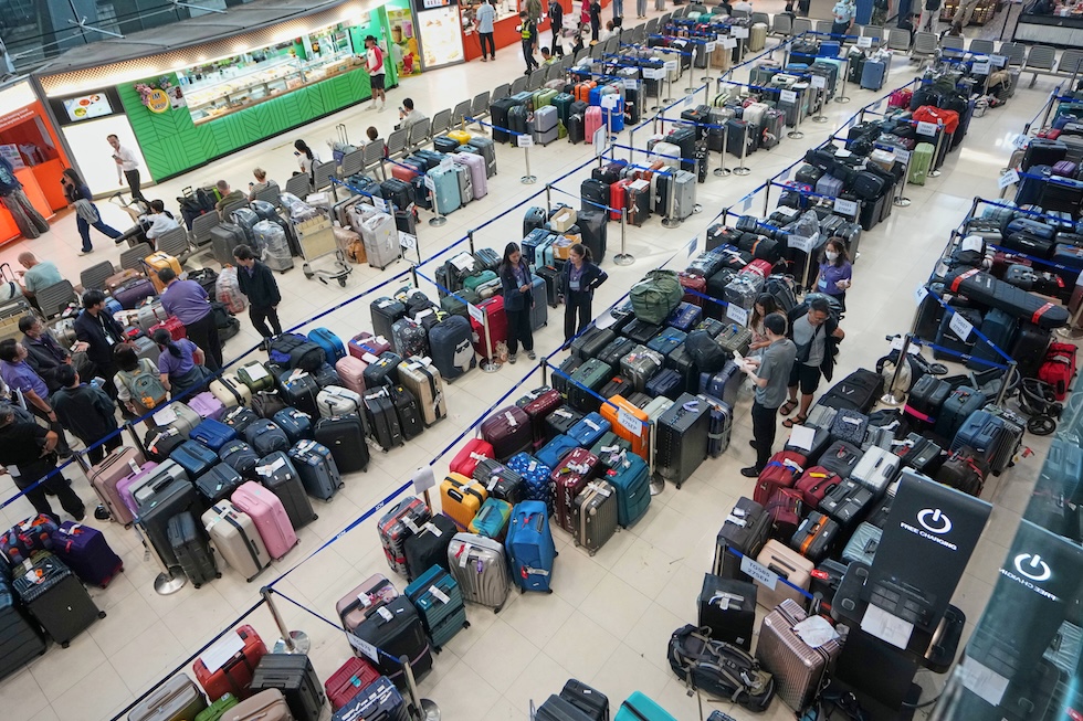 File di bagagli non consegnati nella sala arrivi dell’aeroporto internazionale Suvarnabhumi, dopo che forti piogge e allagamenti a Bangkok hanno impedito ai lavoratori dell’aeroporto di recarsi al lavoro(AP Photo/Sakchai Lalit)
