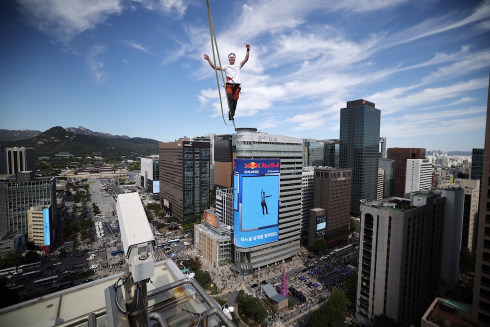 Lo slackliner estone Jaan Roose su una fettuccia lunga 160 metri, sospesa a 120 metri dal suolo, durante un evento di slackline ad alta quota (Kim Hong-Ji/Pool Photo via AP)