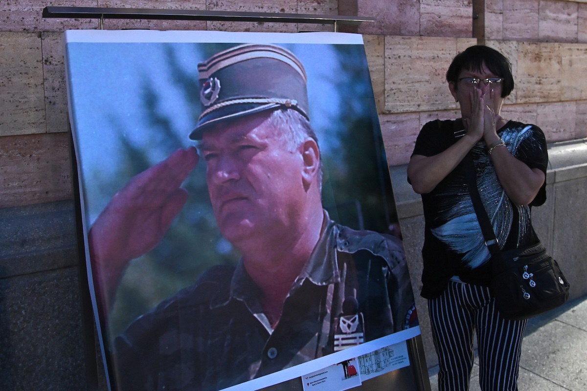 Una donna davanti a un poster che raffigura Ratko Mladić a Banja Luka, la principale città della Republika Srpska, il 27 agosto (AP/Radivoje Pavicic)
