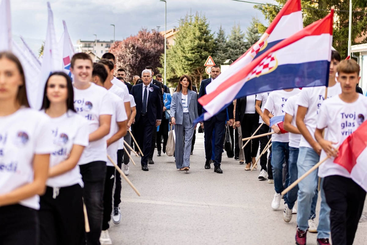 Darijana Filipović, la candidata del partito nazionalista croato HDZ BiH alla presidenza, a un evento elettorale. Le bandiere sulla destra sono quelle della repubblica croata di Herceg Bosna, che i croati formarono durante la guerra per cercare di rendersi autonomi. Anche queste bandiere sono un simbolo nazionalista estremamente controverso in Bosnia Erzegovina (foto tratta dal profilo Facebook dell'HDZ BiH).
