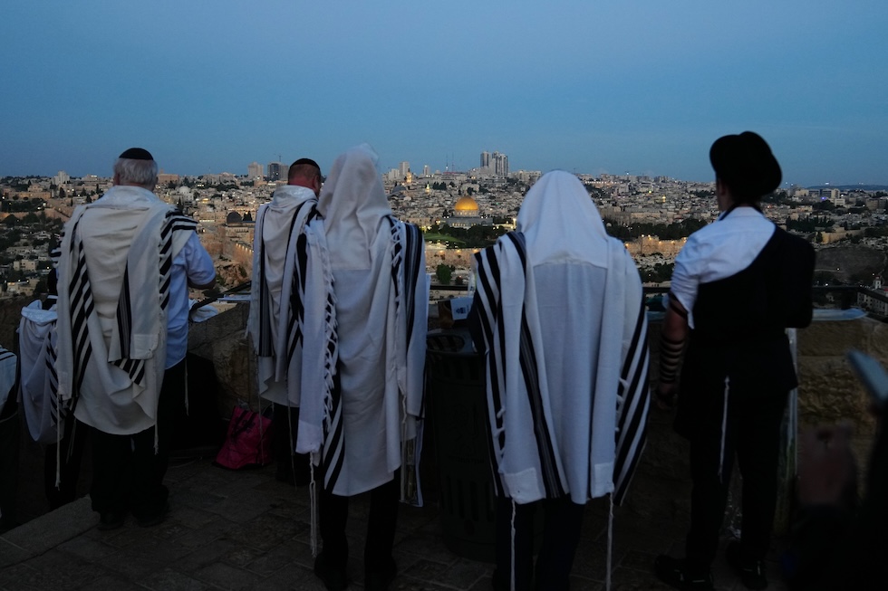Ebrei ultraortodossi pregano durante Hoshana Rabbah, il settimo giorno della festa ebraica di Sukkot, sul monte degli Ulivi, con vista sulla cupola della Roccia (AP Photo/Mahmoud Illean)
