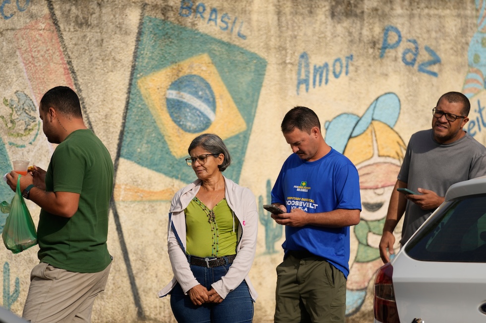 Elettori in coda a un seggio elettorale per il primo turno delle elezioni presidenziali: ci sarà un turno di ballottaggio tra Luiz Inácio Lula da Silva e Flávio Bolsonaro (AP Photo/Eraldo Peres)