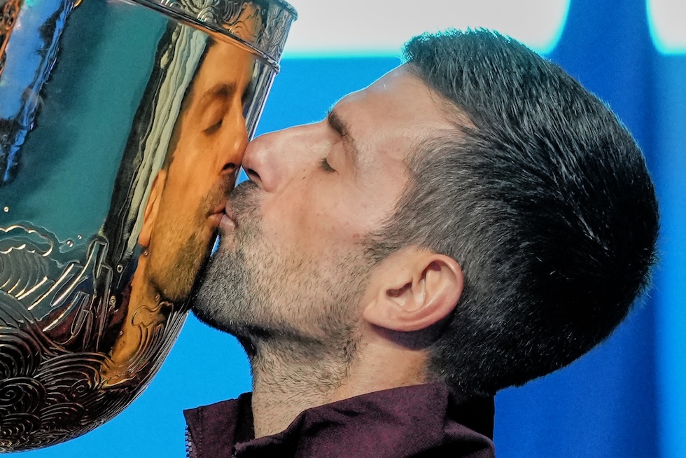 Il tennista serbo Novak Djokovic bacia la coppa dell'ATP 500, il primo trofeo che ha vinto nel 2026, battendo in finale l'australiano Alex De Minaur (AP Photo/Achmad Ibrahim)