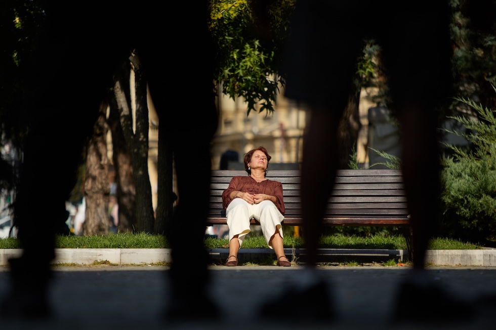Una donna riposa su una panchina (AP Photo/Alexandru Nechez)