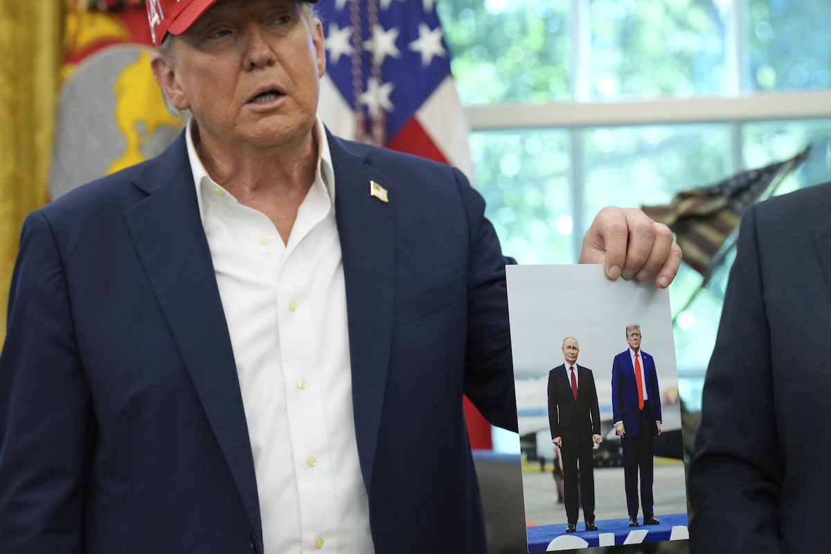 Trump mostra una sua foto con Putin, agosto 2025 (AP Photo/Jacquelyn Martin)