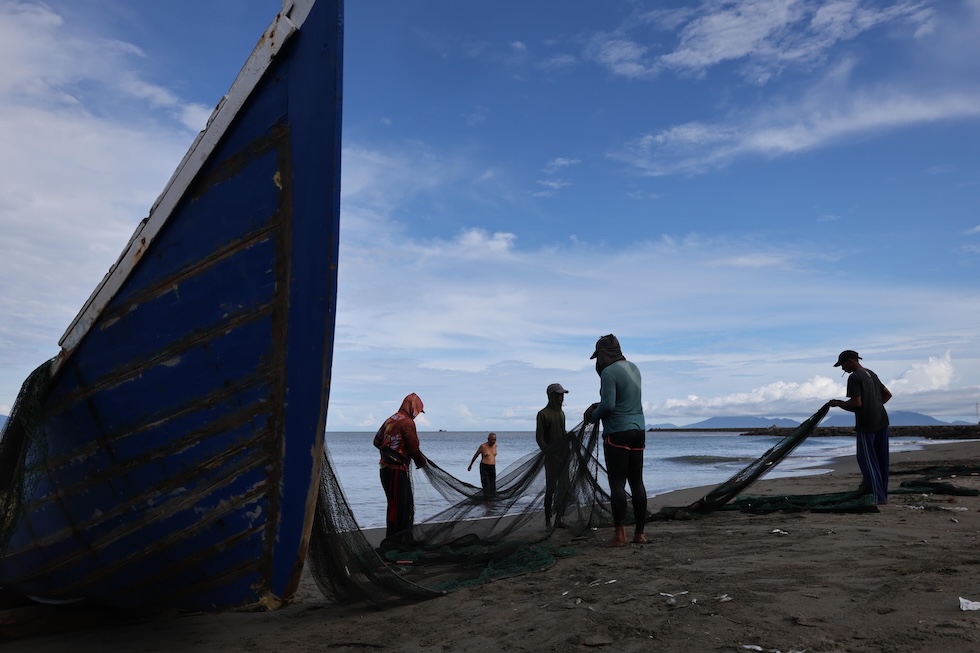 Pescatori sistemano una rete dopo la pesca (EPA/HOTLI SIMANJUNTAK/ansa)