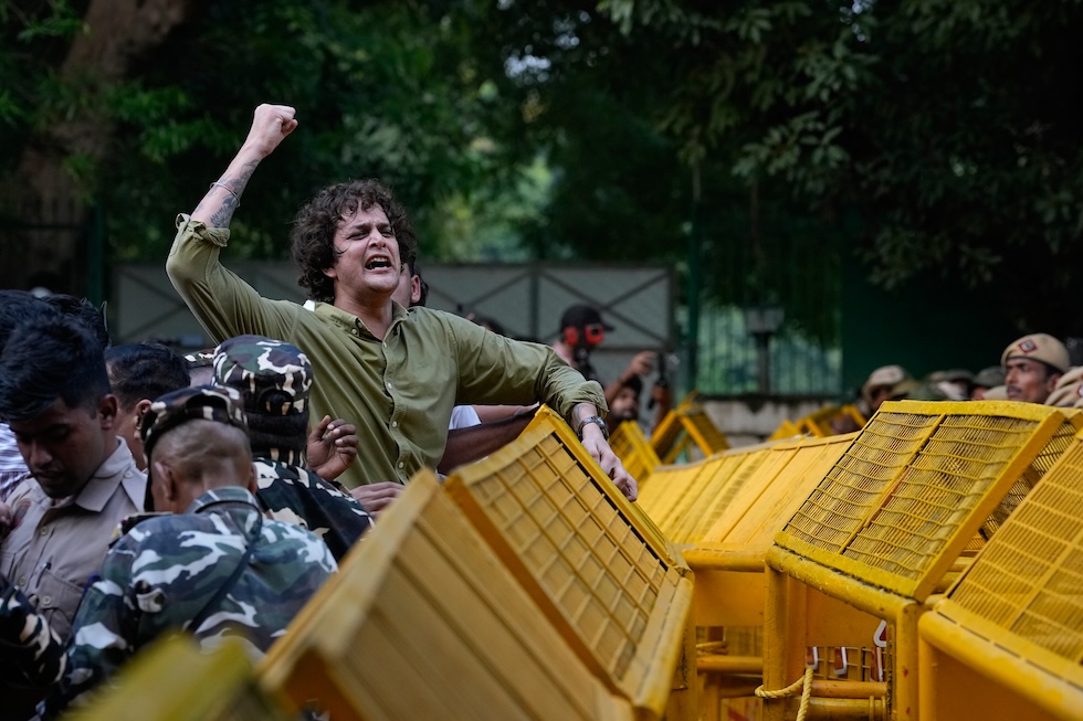 Un manifestante contro le barricate della polizia durante un corteo dei partiti di opposizione diretto alla Corte Suprema, per chiedere le dimissioni di Gyanesh Kumar, presidente della commissione elettorale. Da settimane in India ci sono proteste quotidiane contro la decisione della commissione elettorale di cancellare dalle liste elettorali 130 milioni di persone (AP Photo/Manish Swarup)