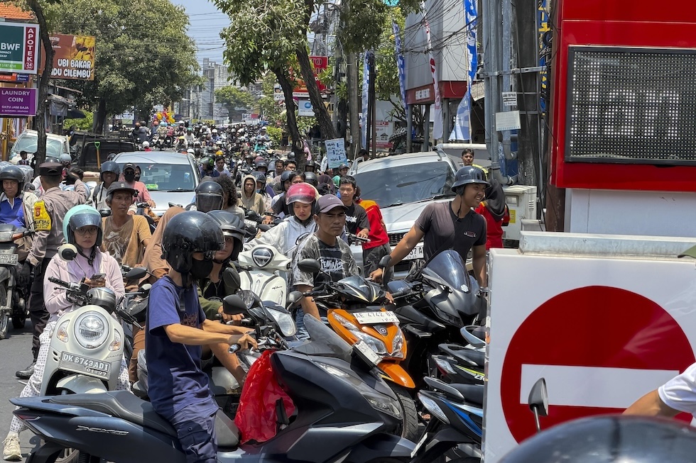 Persone in moto in coda per fare rifornimento in una stazione di servizio a Bali (EPA/MADE NAGI/ansa)