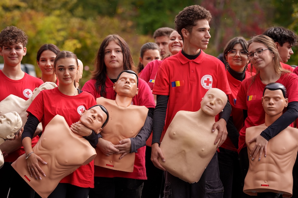 Volontari della Croce Rossa rumena con in mano dei manichini a un flash mob per la Giornata mondiale della rianimazione cardiopolmonare(AP Photo/Vadim Ghirda)