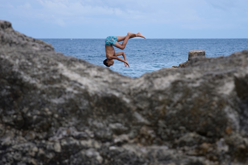 Un ragazzo si tuffa da uno scoglio a Beirut (AP Photo/Hassan Ammar)